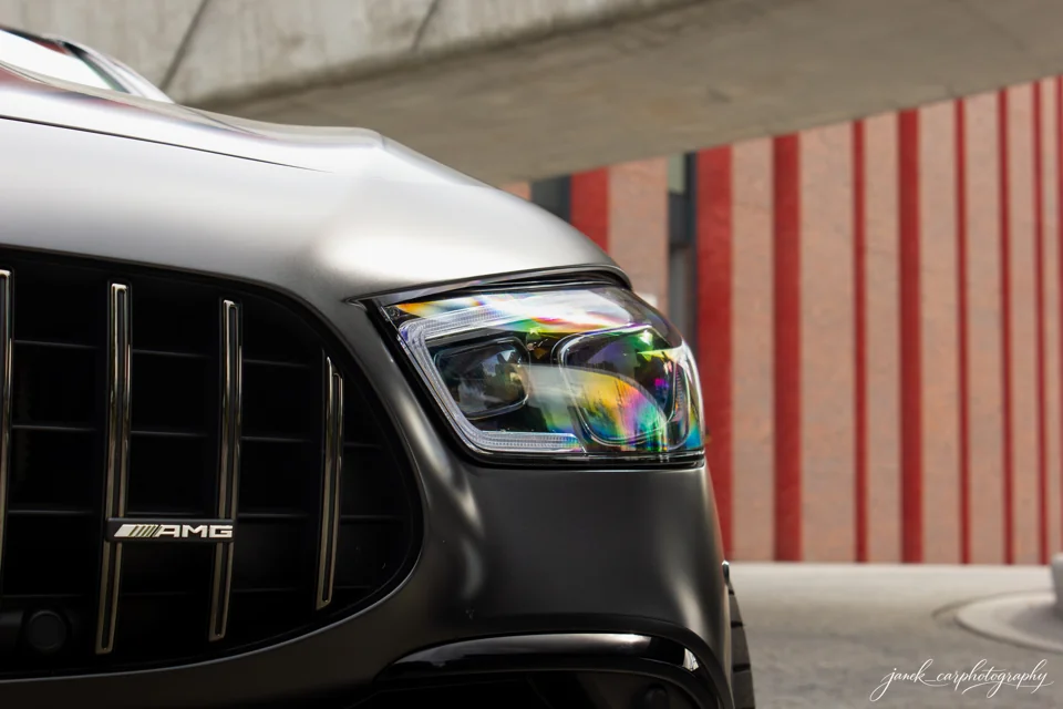 Zbliżenie reflektora i grilla srebrnego Mercedesa-AMG